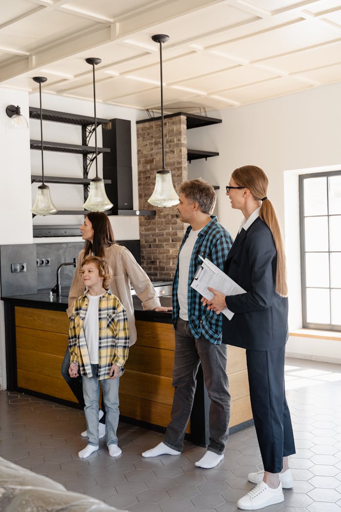 services-02 Family exploring a modern home kitchen with a real estate agent, showcasing buying opportunities.
