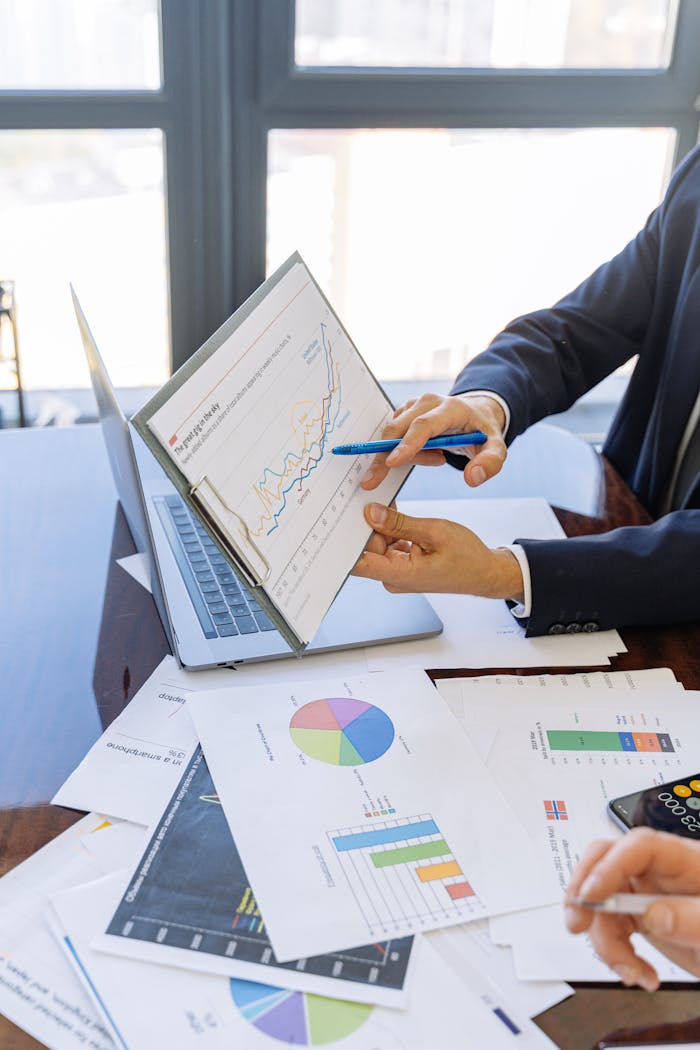 portfolio-03 Business professionals discussing financial graphs and charts in an office setting.